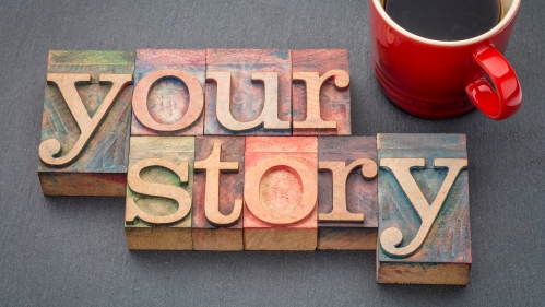 wooden letter blocks spelling out "your story" next to a mug of coffee