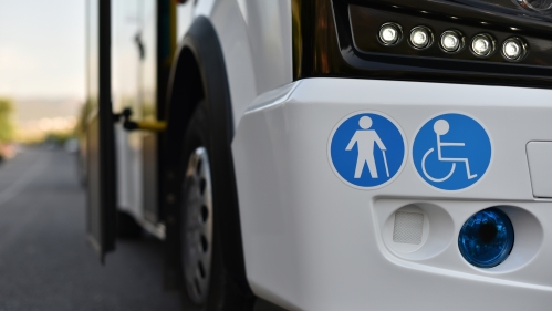 a vehicle with symbols of a cane user and a wheelchair user on the front bumper