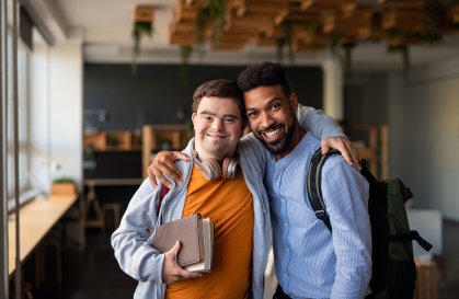 two men with their arms around each other in a classroom setting